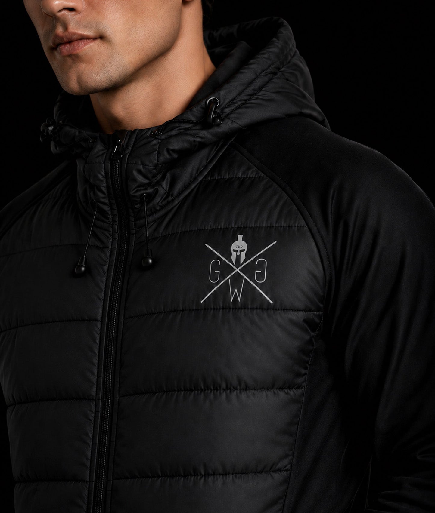 Close-up der schwarzen Gym Generation Hybridjacke mit reflektierendem Logo, Kapuze und leicht gefüttertem Frontbereich