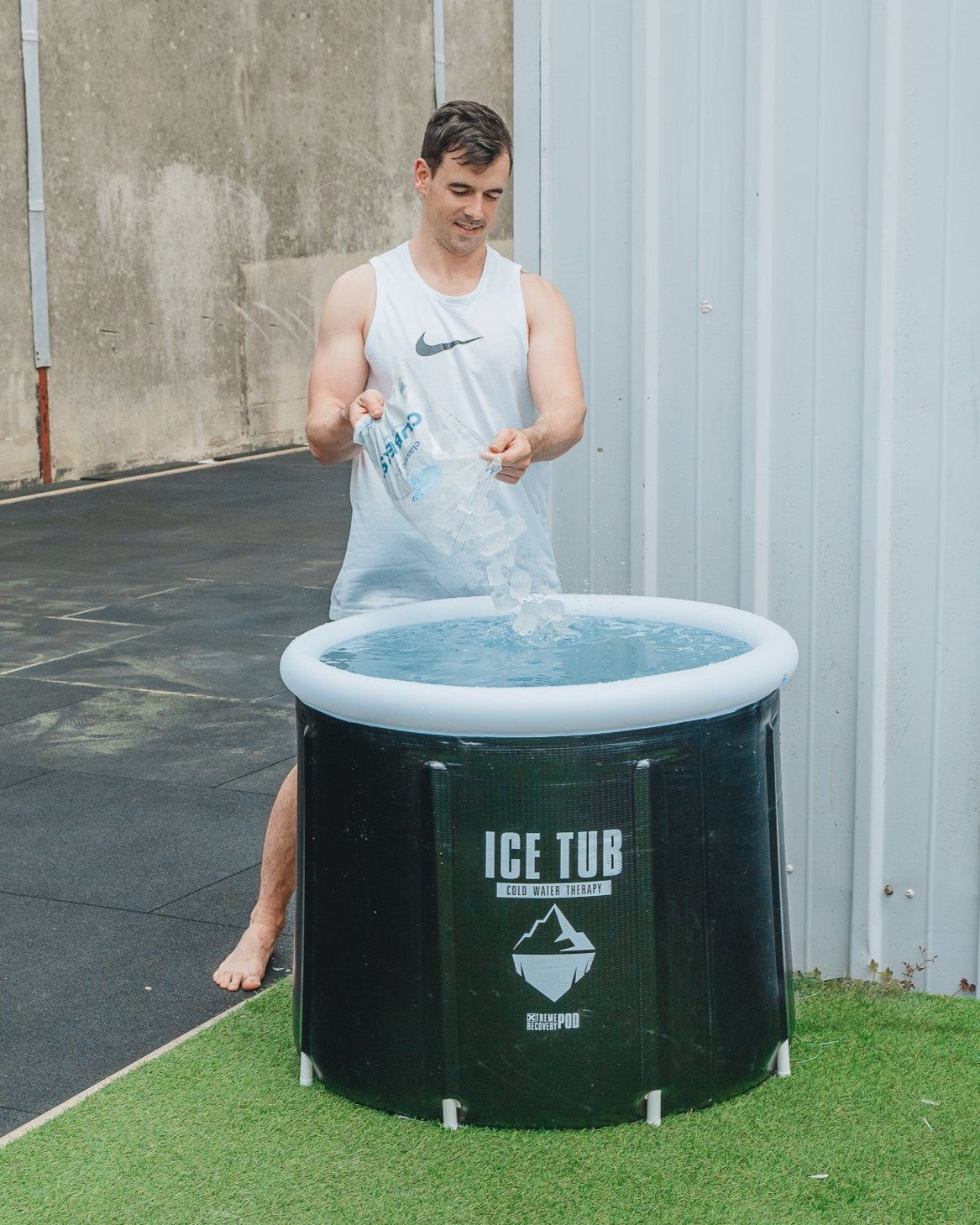 Mann fügt Eiswürfel in eine Eistonne für Kältetherapie hinzu, ideal für Regeneration und Muskelwiederherstellung nach dem Training.