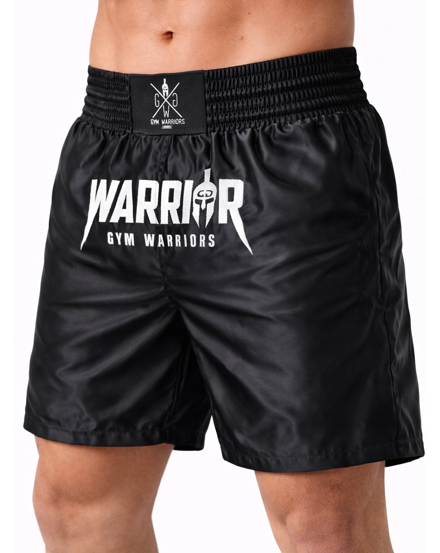 Schwarze Muay Thai Fight Shorts von Gym Generation in schräger Seitenansicht – mit glänzendem Material, breitem Bund und markantem Warrior Print