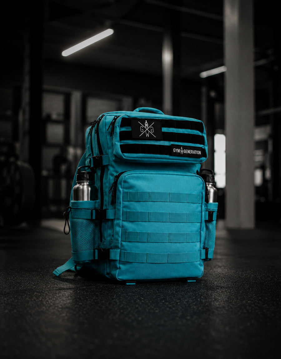Gym Generation Fitness Rucksack Adventurer in Surf Blue, freistehend im Fitnessstudio mit MOLLE-System, Patches und seitlichen Flaschenfächern