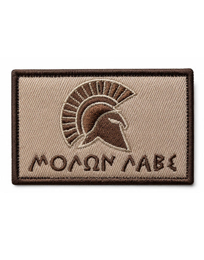 Molon Labe Patch Bronze mit Klett – Spartaner-Helm im Profil über Molon-Labe-Schriftzug in griechischen Buchstaben, Sand- und Bronzetöne, rechteckig gestickt.