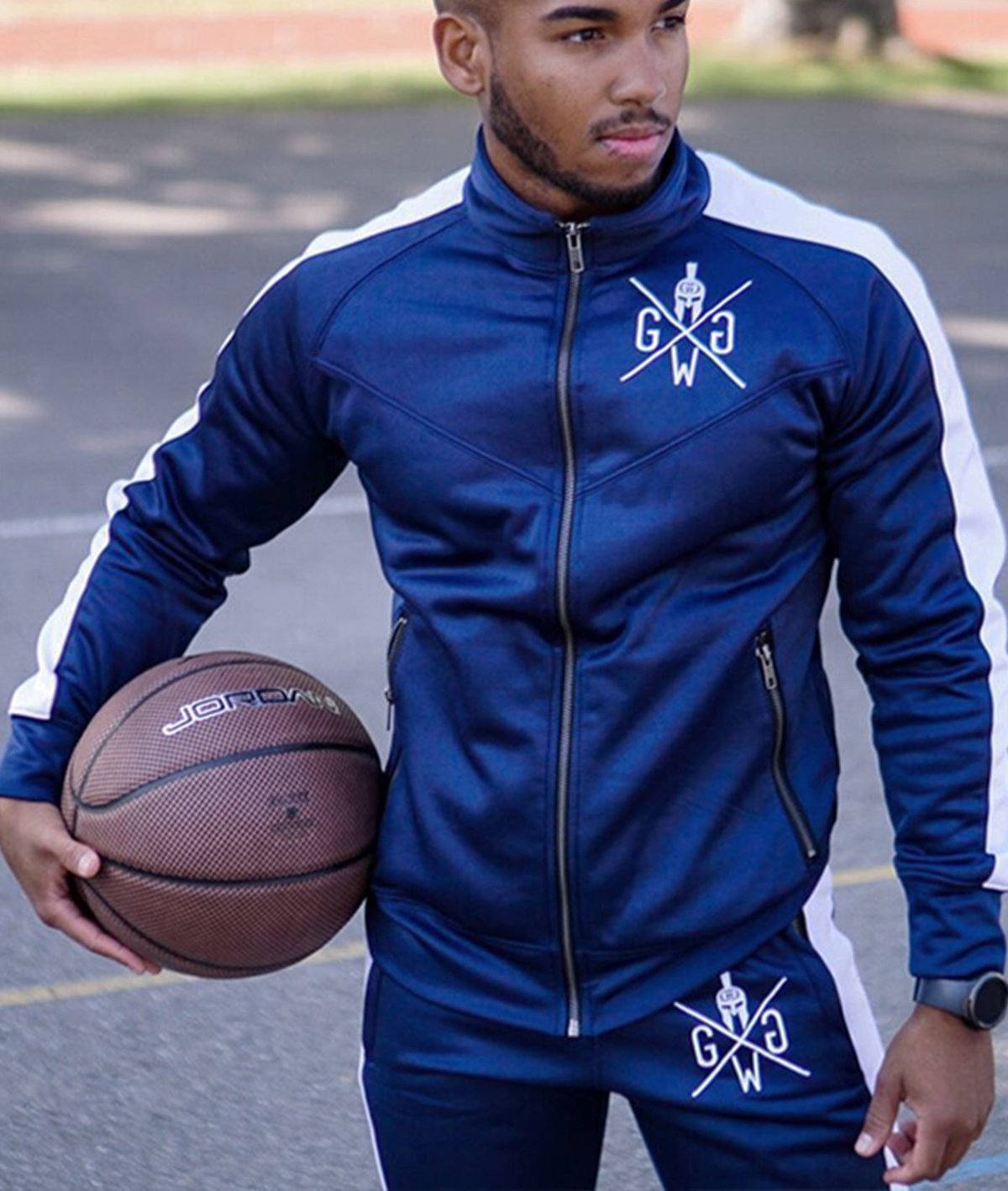 Dunkelblaue Trainingsjacke von Gym Generation getragen von einem Modell mit Jordan Basketball.