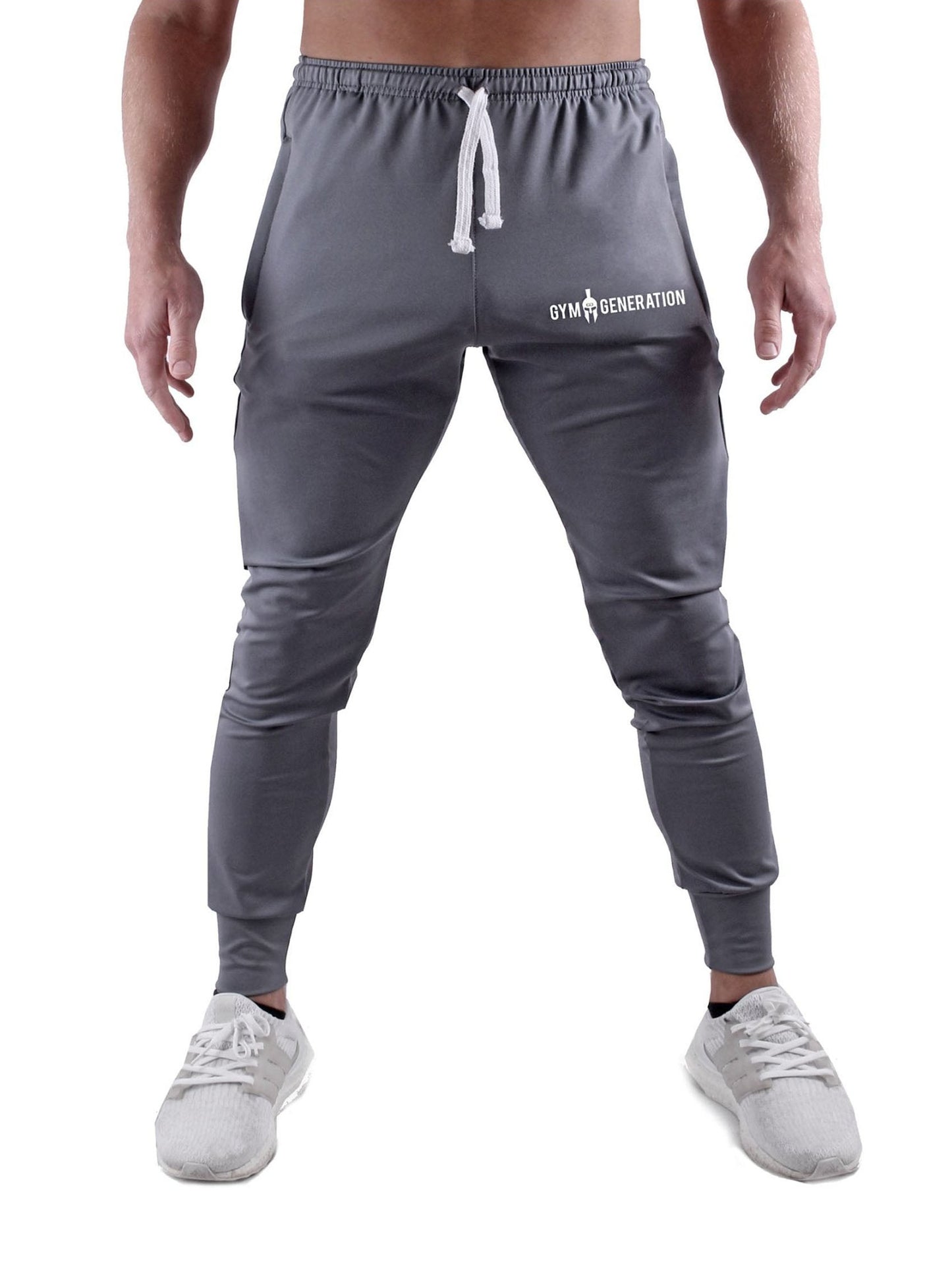 Gym Generation Trainer Pants in stilvollem Grau, getragen von sportlichen Männern mit Sneakers.