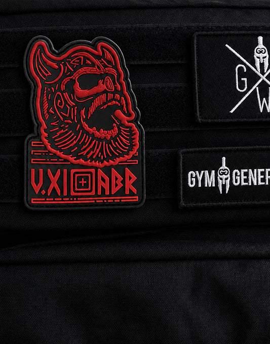 Berserker Patch auf dem Klettpanel eines schwarzen Gym Generation Rucksacks neben zwei Logo-Patches
