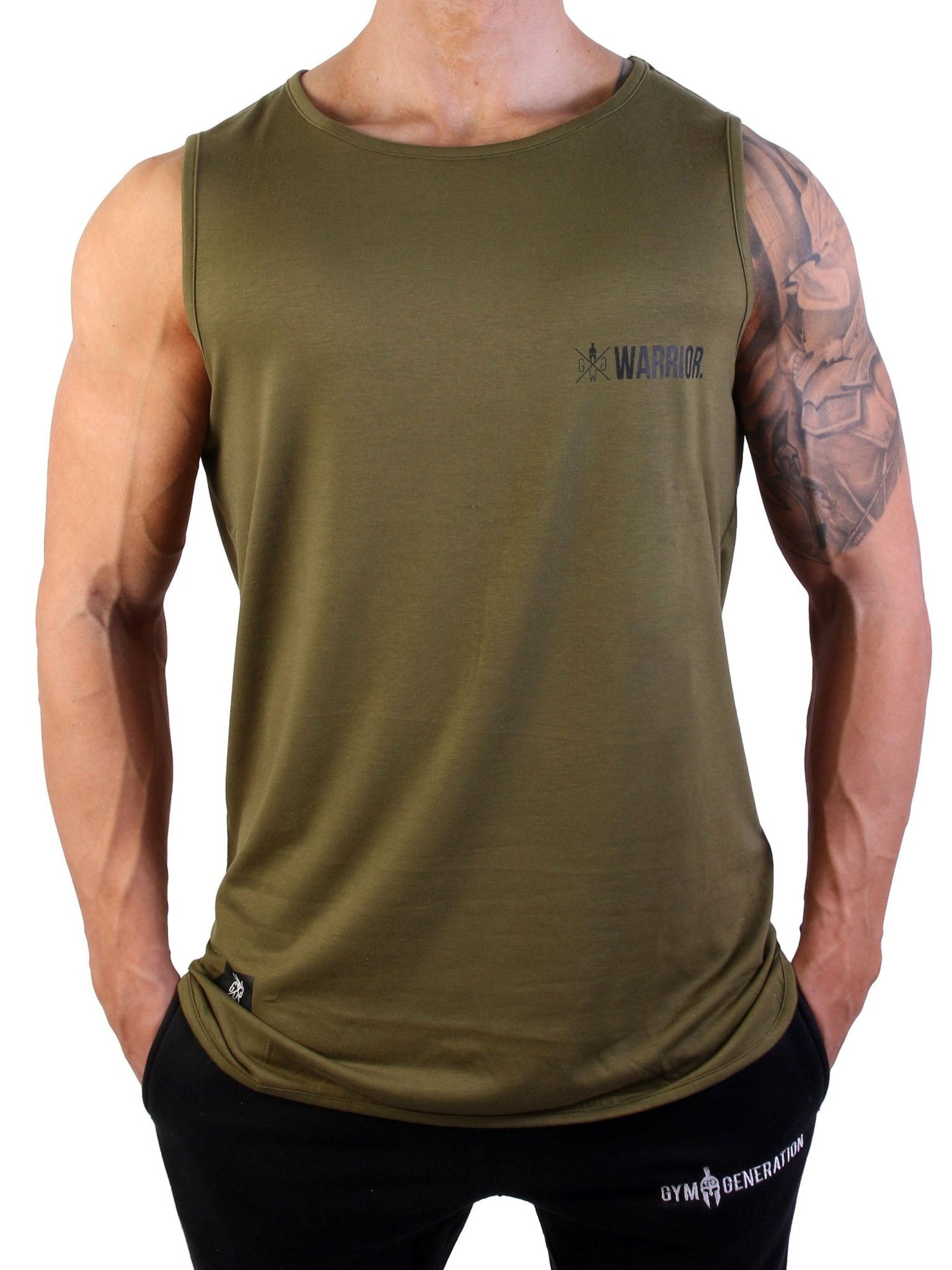 Nahaufnahme eines Fitnessmodells im Gym Generation Fitness Tank Top 'Warrior' in Olive, mit dezentem Warrior-Logo auf der Brust und sportlicher Jogginghose.