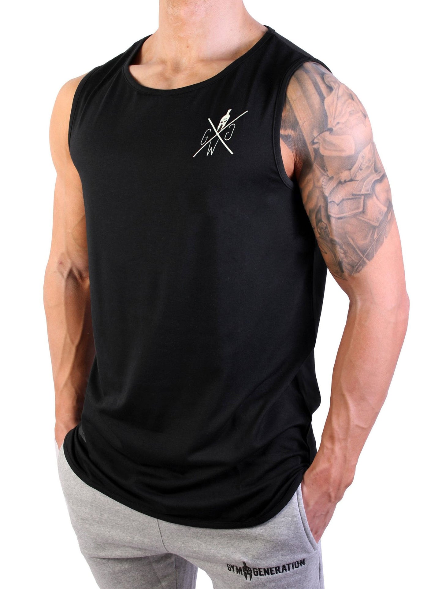 Mann trägt Gym Generation Muscle Tank Top in Schwarz, zeigt den Frontprint mit dezentem Logo.