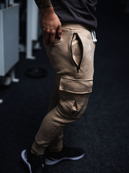 Moderne beige Cargo Trainerhose von Gym Generation mit dezentem weißen Spartaner-Logo, ideal für Athleten und Freizeit