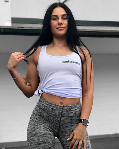 Frauen fitness-Model trägt das Gym Generation Fitness Top in Hellblau und kombiniert es mit grauen Leggings, sportlicher Look für Gym und Freizeit.