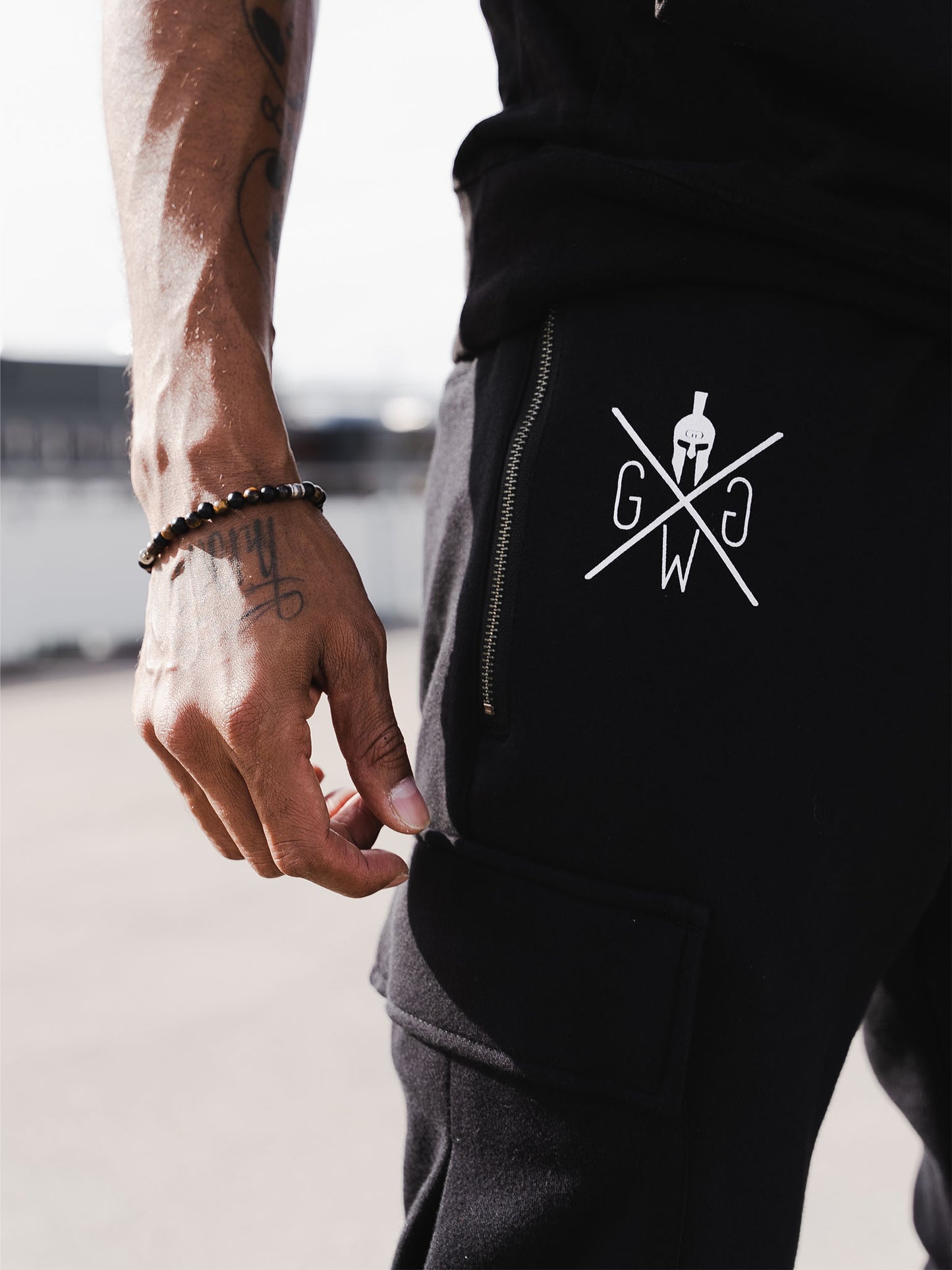 Gym Generation Herren Cargo Trainerhose in Schwarz, ausgestattet mit fünf praktischen Taschen für Handy, Schlüssel und mehr.