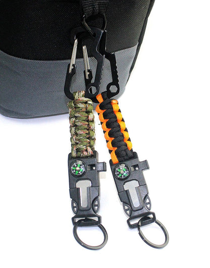 Gym Generation multi-tool keychains clipped to a bag handle – carabiner hooked on, buckle with compass, fire starter and whistle, key ring below