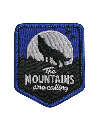 Berg-Patch mit Wolf und „The Mountains Are Calling“-Schriftzug – hochwertig gesticktes Design in Blau, Schwarz und Weiß, ideal für Rucksäcke, Kleidung und Outdoor-Zubehör.